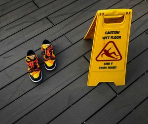 Pair of yellow training shoes on a dark wooden floor